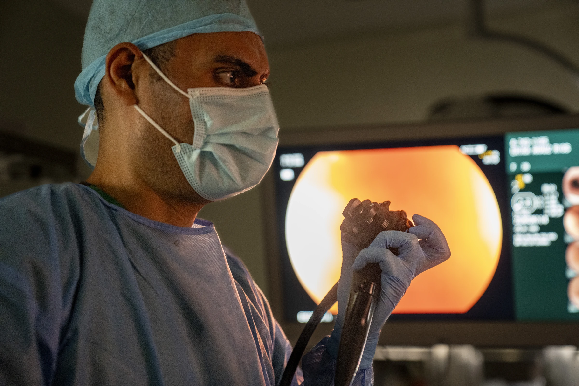 Profissional realizando procedimento endoscópico com endoscópio e monitor
